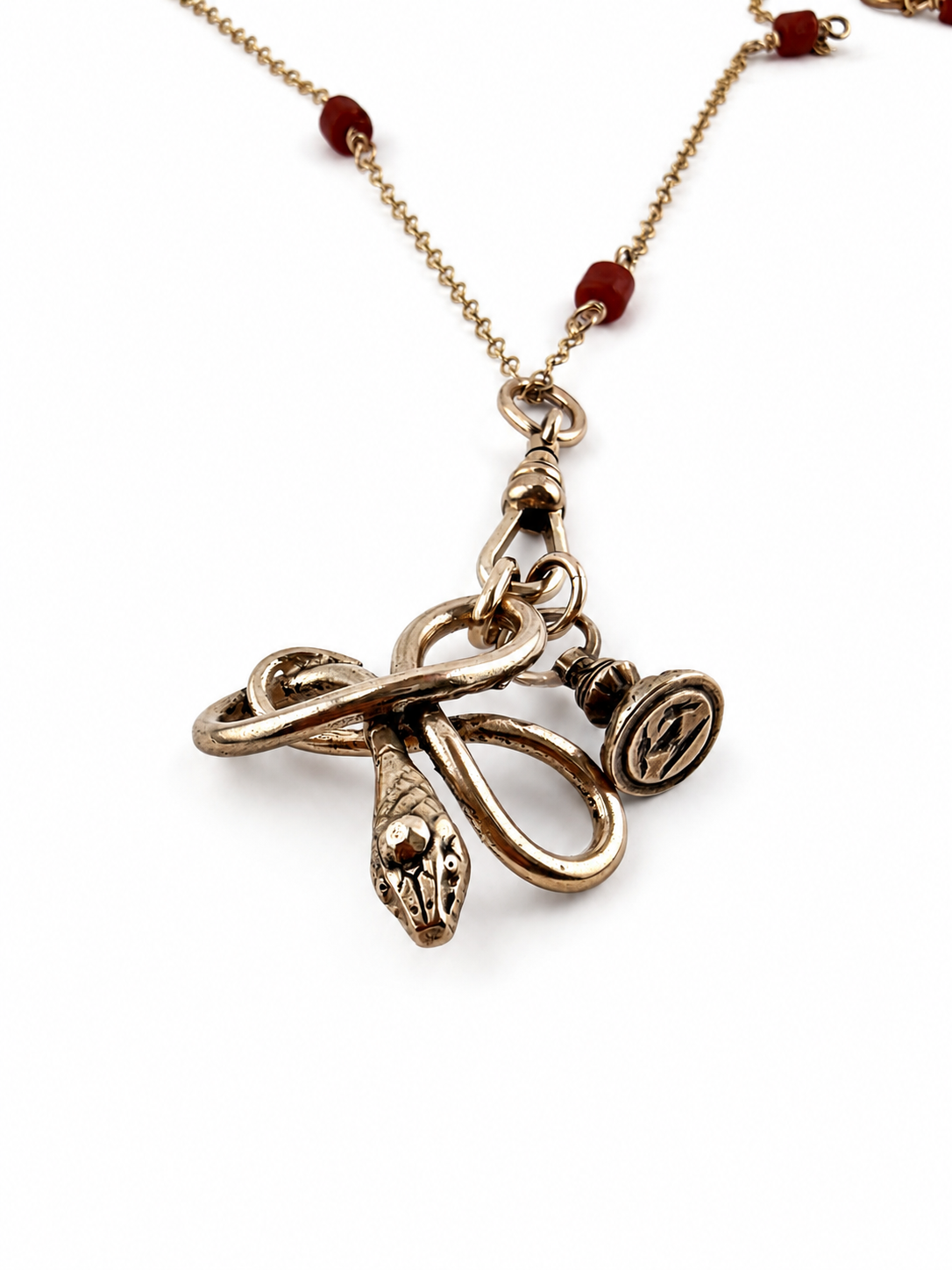 
                  
                    SERPENT Charm Necklace in Bronze with Mediterranean Coral
                  
                