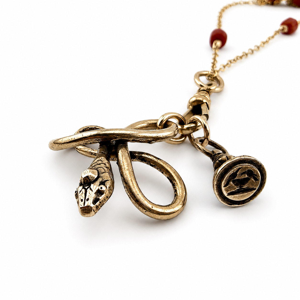 
                  
                    SERPENT Charm Necklace in Bronze with Mediterranean Coral
                  
                